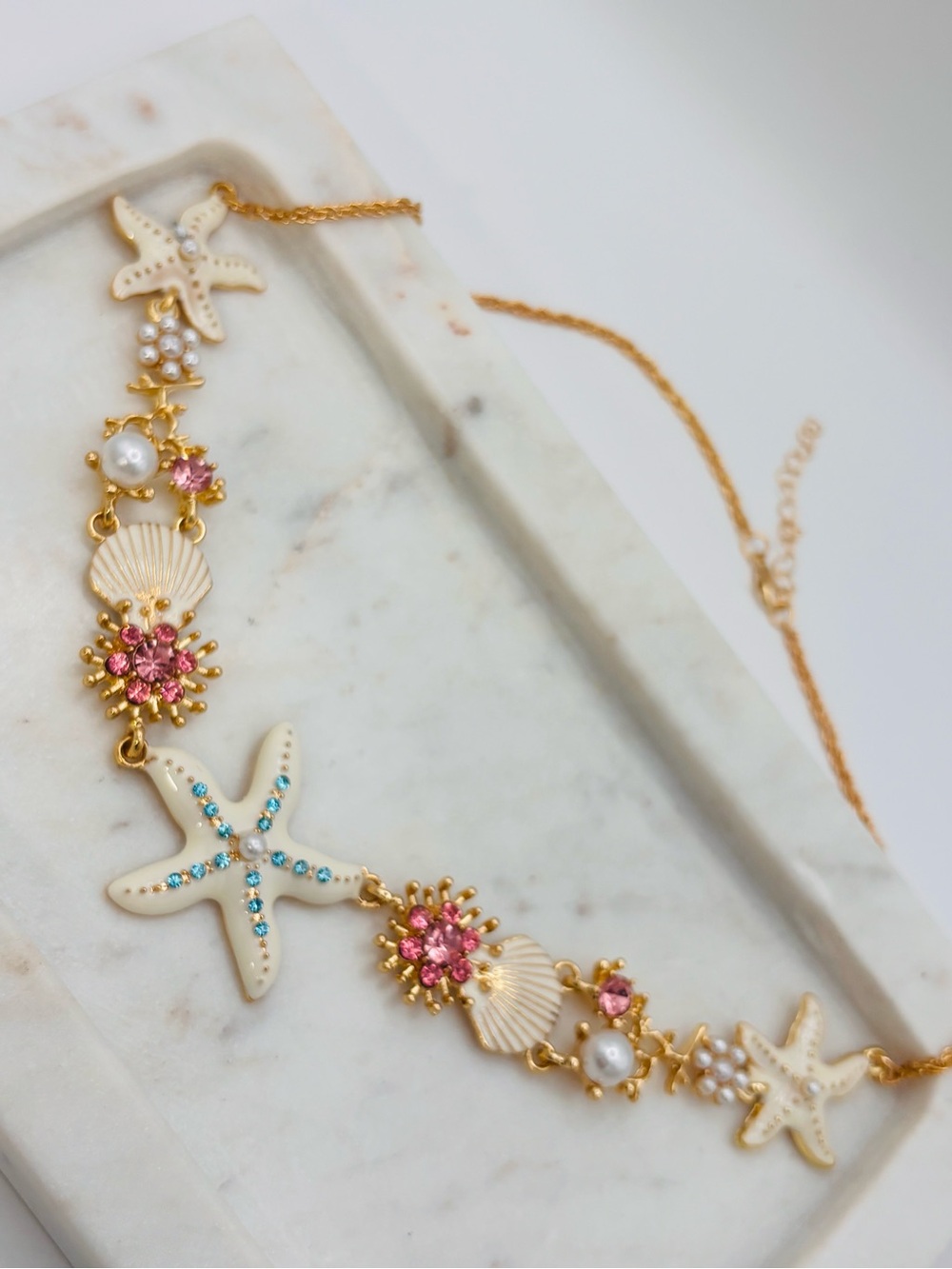 Off-white starfish necklace with pearls .